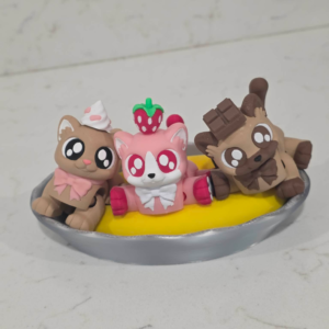 3D printed Banana Splitten Kittens featuring strawberry, vanilla, and chocolate dessert-themed cats sitting in a banana split dish with a sliced banana base, cute collectible cat figures.